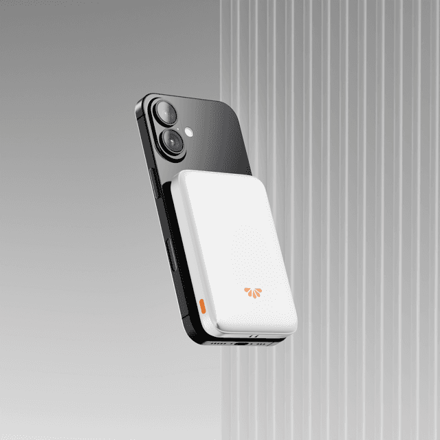 Smartphone floating with a white magnetic battery pack against ridged background